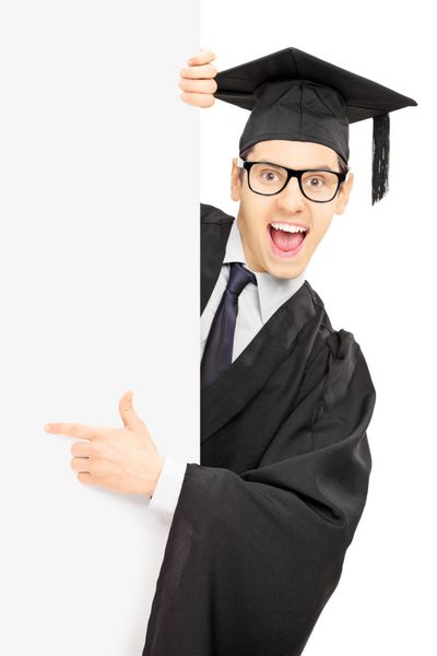 دانشجوی پسر فارغ التحصیل که از پشت تابلوی خالی نگاه می کند و با انگشت جدا شده روی پس زمینه سفید نشان می دهد