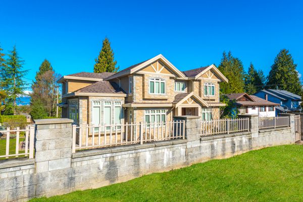 خانه لوکس سفارشی بزرگ پشت حصار با چمن حیاط جلویی زیبا و آراسته شده در حومه ونکوور کانادا