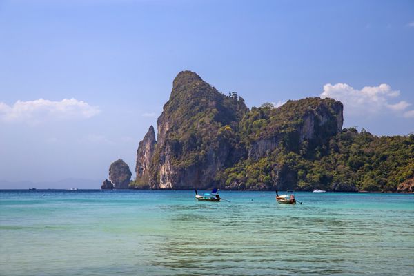صخره های زیبا در ساحل دریا و قایق های دم دراز در جزایر فی فی تایلند