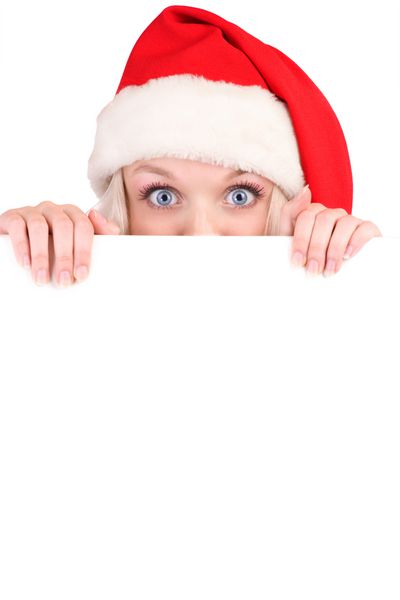 زن زیبای کریسمس با کلاه بابانوئل که تخته خالی در دست دارد