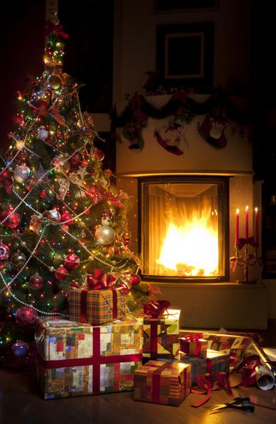 جعبه های درخت کریسمس و هدیه کریسمس در فضای داخلی با شومینه