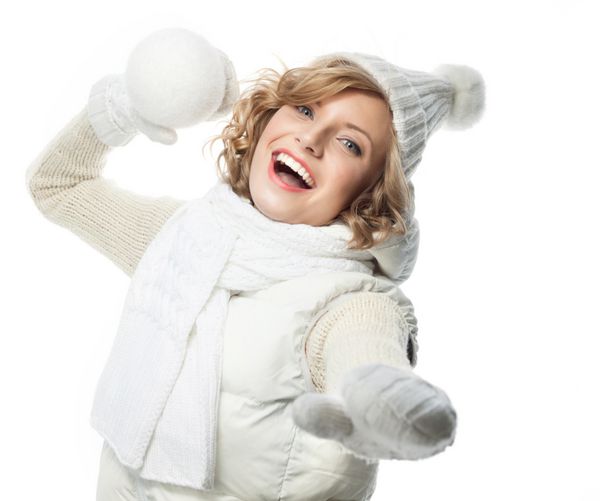 زن جوان قفقازی جذاب با لباس گرم در استودیو جدا شده روی سفید لبخند می زند