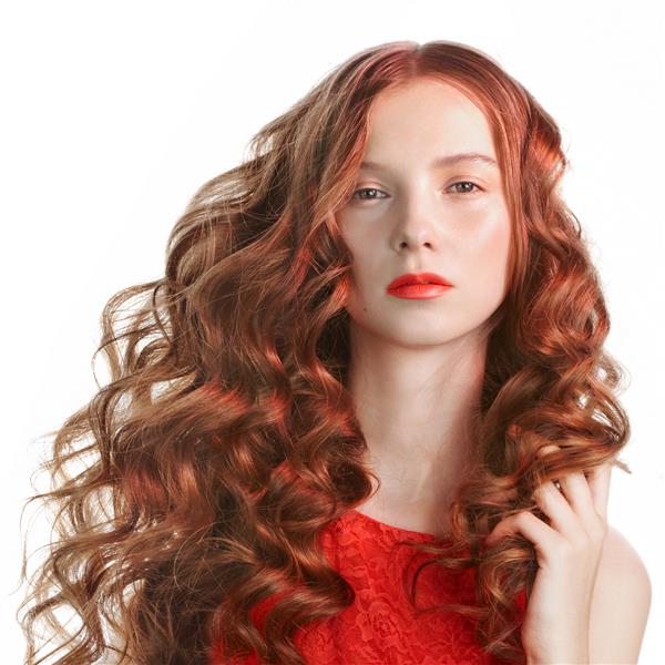 زن جوان زیبا با موهای مجعد بلند در نور قرمز