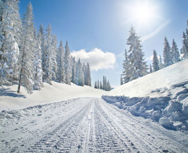جاده پوشیده از برف خالی در چشم انداز زمستانی