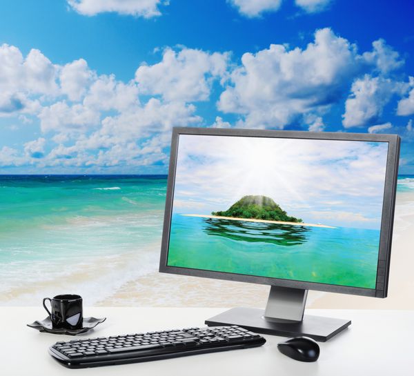 دفتر آفتابی روشن با یک کامپیوتر در ساحل