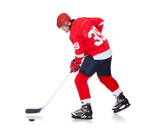 بازیکن حرفه ای هاکی که روی یخ اسکیت می کند جدا شده روی سفید