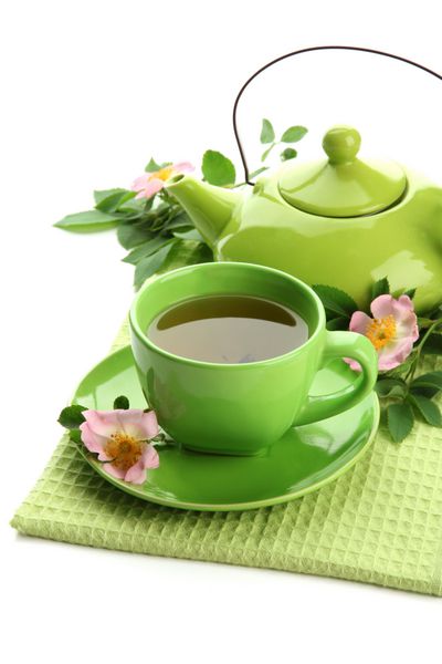 فنجان و قوری چای گیاهی با گل های رز هیپ جدا شده روی سفید