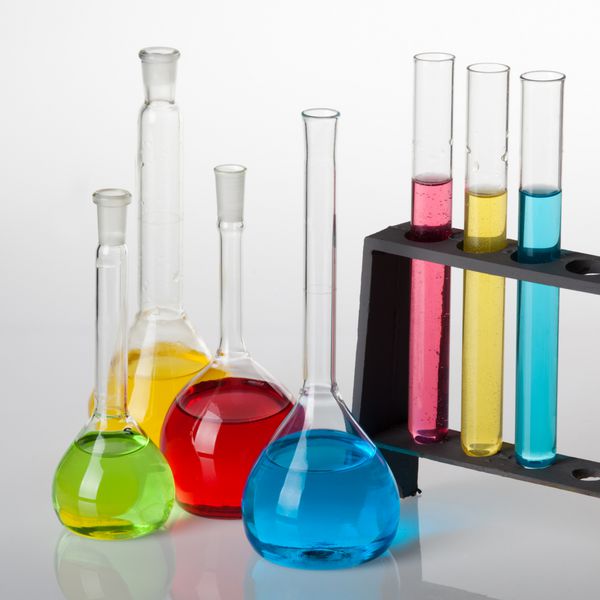 مجموعه شیمی با لوله های آزمایش و لیوان های پر از مایعات چند رنگ