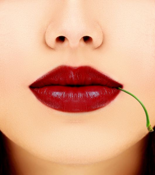 دهان زنانه با گیلاس قرمز مفهوم- براق لب میوه ای