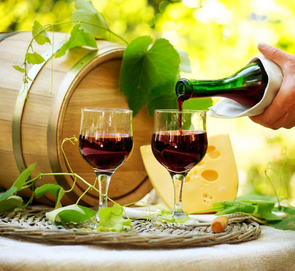 شراب شراب قرمز و پنیر ناهار رمانتیک در فضای باز ریختن شراب از نمای نزدیک بیرون از خانه