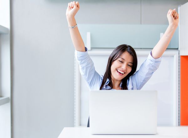 زن تجاری موفق با بازوهای بالا در دفتر