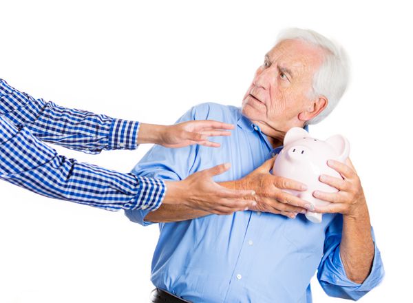 پرتره ای نزدیک از یک سالخورده مرد سالخورده پدربزرگ که قلک را در دست دارد ترسیده به نظر می رسد سعی می کند از پس انداز خود در برابر سرقت محافظت کند جدا شده روی پس زمینه سفید کلاهبرداری مالی