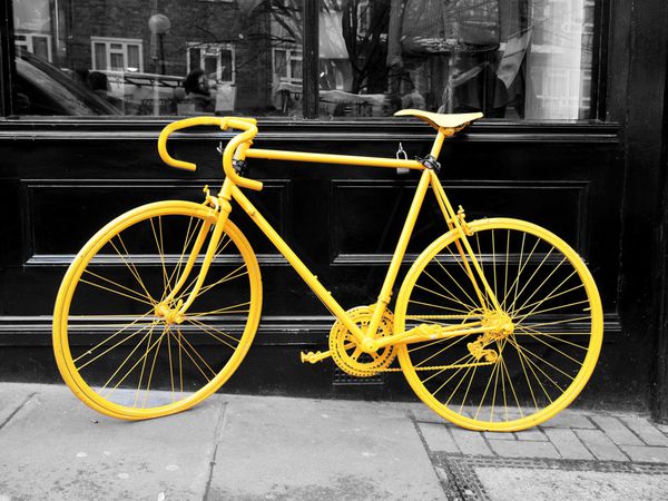 عکس دوچرخه زرد قدیمی روی ویترین کافی شاپ
