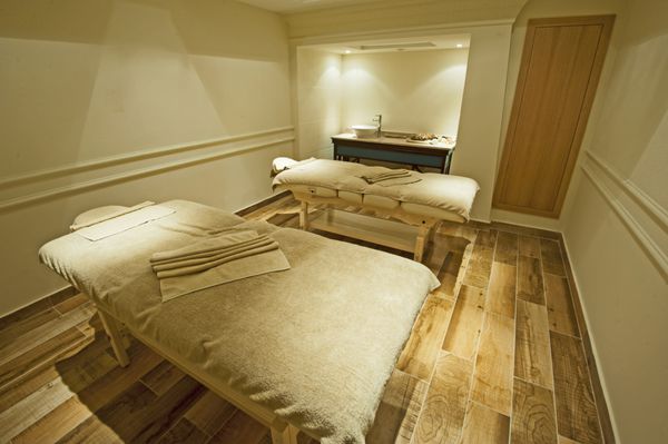 دو تخت ماساژ در اتاقی در اسپای سلامت لوکس