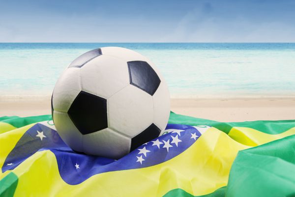 توپ فوتبال با پرچم برزیل در ساحل