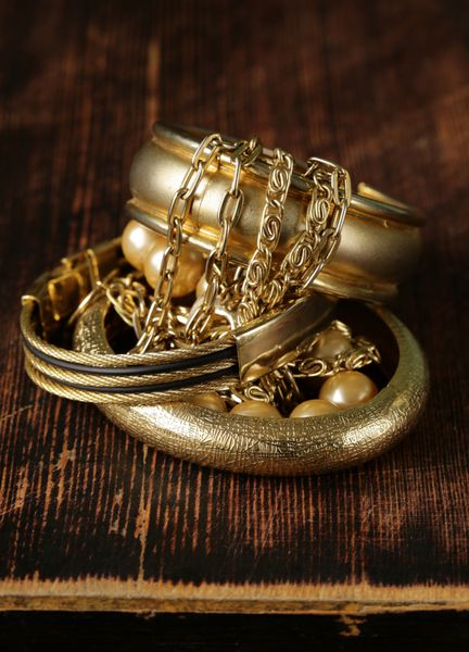 جواهرات طلا و مروارید در زمینه چوبی قدیمی