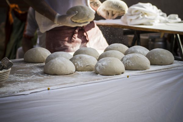 نانوا در یک نمایشگاه قرون وسطایی نان مصنوعی درست می کند