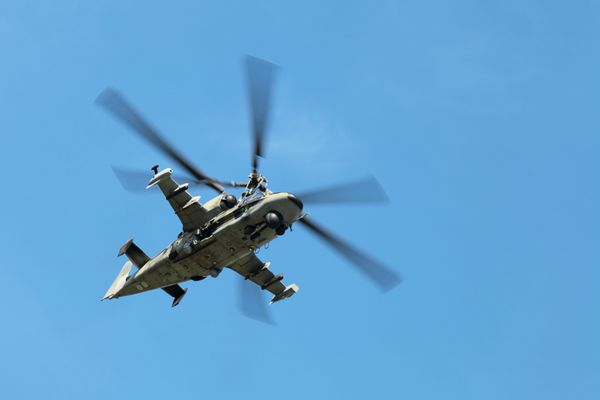 یک هلیکوپتر نظامی در حال پرواز در پس زمینه آسمان آبی