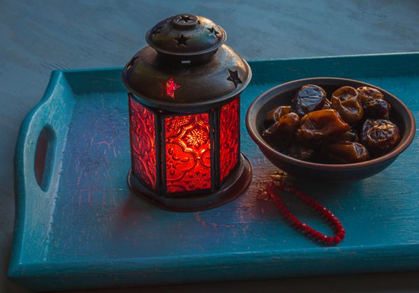 چراغ رمضان و خرما در سینی چوبی