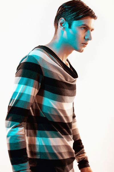 پرتره یک مدل مرد خوش تیپ که در استودیو روی پس زمینه سفید ژست گرفته است