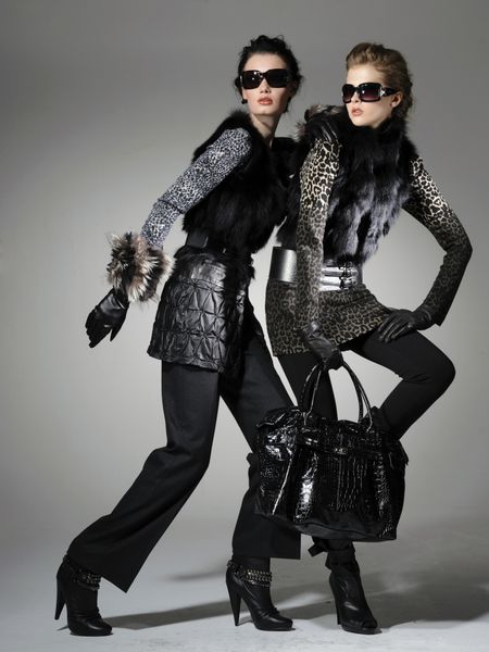 دو مدل مد با عینک آفتابی در حالی که کیف پول خود را در دست گرفته اند
