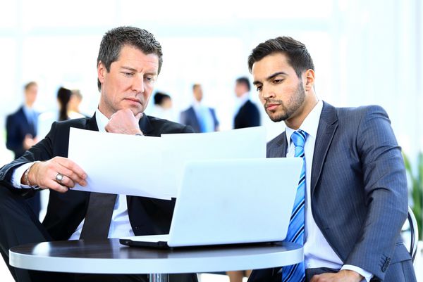 مردان تجارت با هم در یک دفتر بحث می کنند