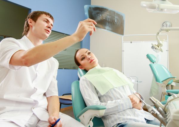 زن جوان با دندانپزشک در یک جراحی دندان