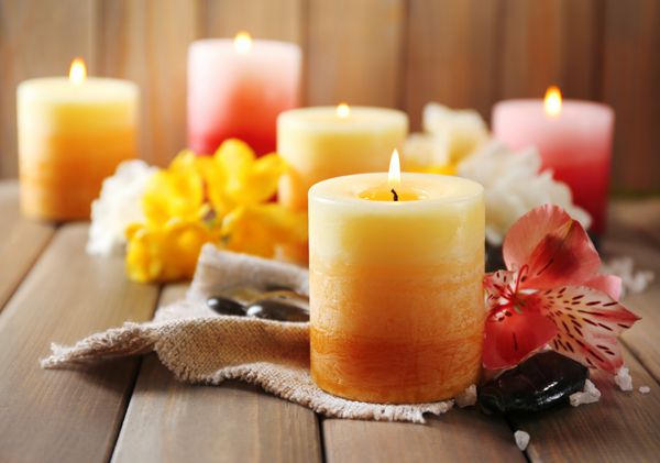 شمع های زیبا با گل در زمینه چوبی