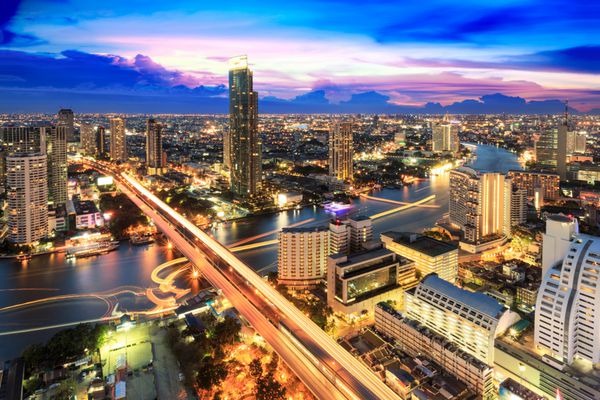 ساختمان مدرن در کنار رودخانه در صحنه گرگ و میش بانکوک تایلند