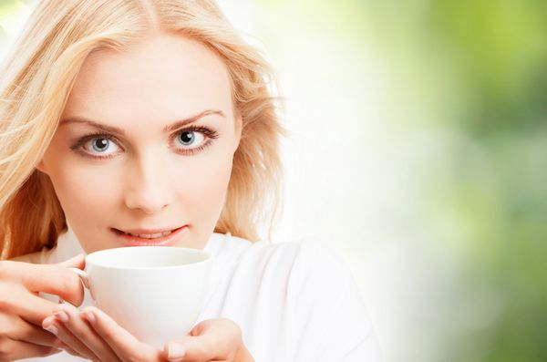 زن جوان با فنجان قهوه یا چای سفید