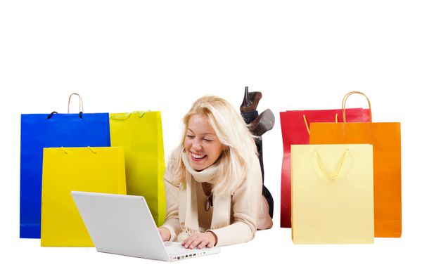 زن زیبا با کیسه های خرید رنگارنگ و لپ تاپ