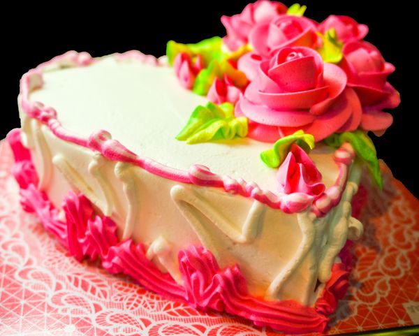 کیک روز ولنتاین یا تولد مبارک با دکور گل رز جدا شده در پس زمینه سیاه
