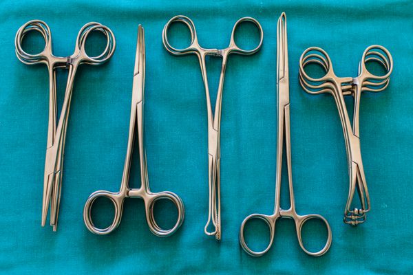 ابزار و ابزار جراحی از جمله چاقوی جراحی پنس و موچین که روی میز برای جراحی چیده شده اند