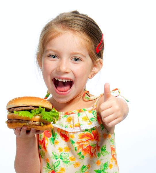 دختر کوچک زیبا در حال خوردن یک ساندویچ جدا شده در زمینه سفید