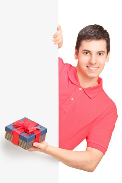 مرد جوان خوشتیپ هدیه ای در دست دارد و پشت تابلوی سفید ایستاده است