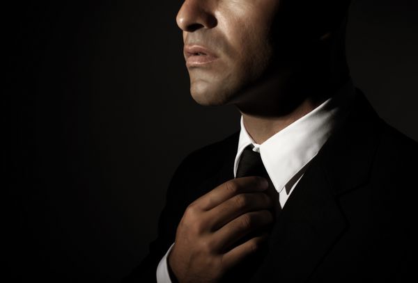 کراوات ثابت مرد خوش تیپ جوان جدا شده در پس زمینه سیاه قسمت صورت تاجر موفق مد مردانه مفهوم زرق و برق