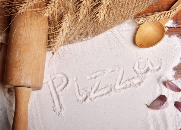 کلمه پیتزا نوشته شده روی آرد - پس زمینه غذا