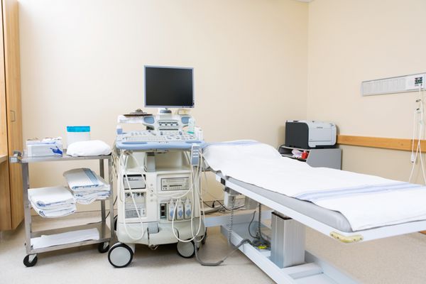 فضای داخلی اتاق بیمارستان با دستگاه سونوگرافی و تخت
