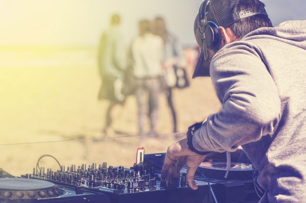 دی جی در حال پخش موسیقی در یک مهمانی ساحلی