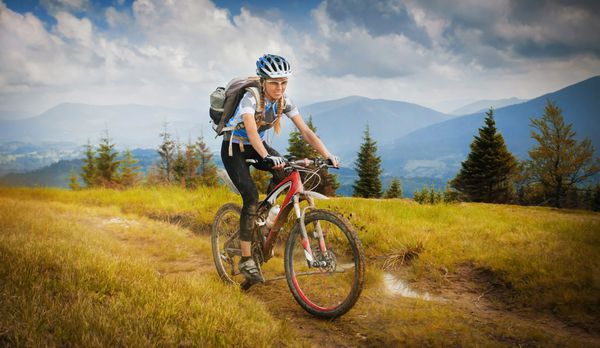 دوچرخه سواری زن روی خط الراس با کوه های کارپات