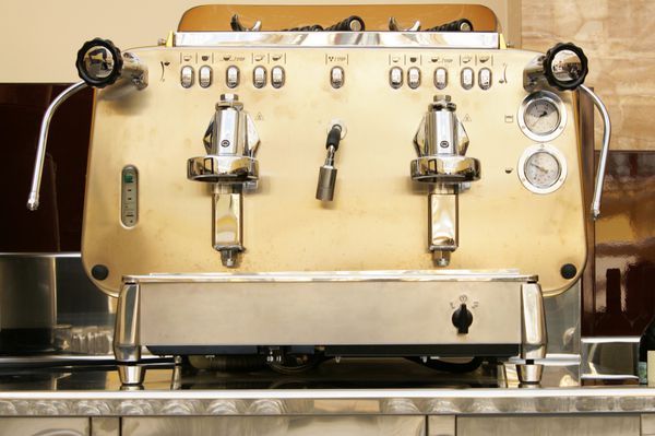 دستگاه قهوه ساز فلزی بزرگ در نمای نزدیک بار
