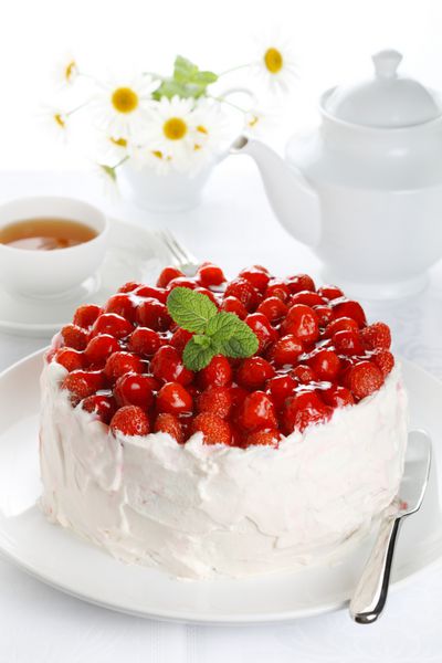 کیک زیبا با توت فرنگی و خامه در پس زمینه جدا شده سفید