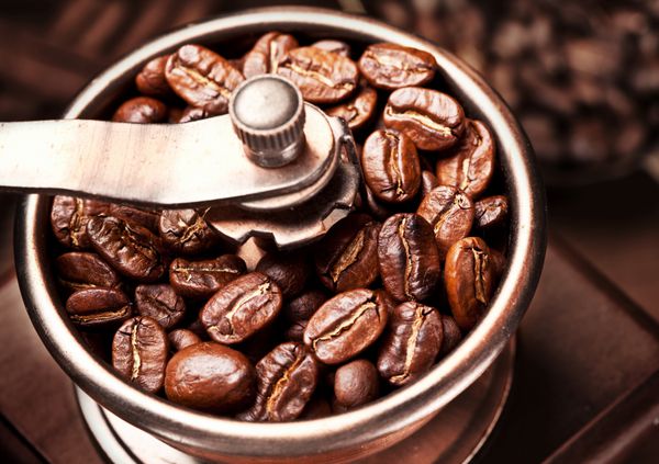 دانه های قهوه بو داده در آسیاب قهوه آسیاب می شوند