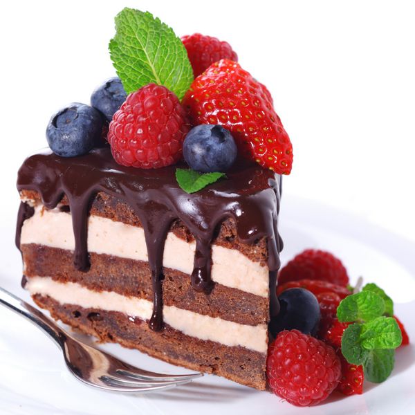 تکه ای از کیک شکلاتی با مایه کیک و توت تازه در پس زمینه جدا شده سفید