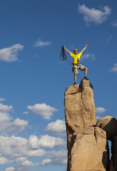 صخره نورد پس از یک صعود موفقیت آمیز و چالش برانگیز در قله تعادل برقرار می کند