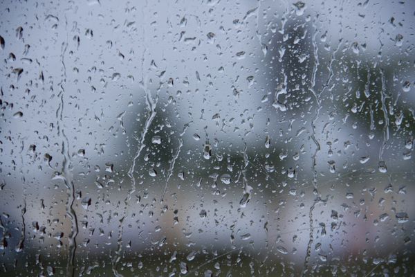 قطره آب قطره باران روی شیشه و چکه کردن پایین