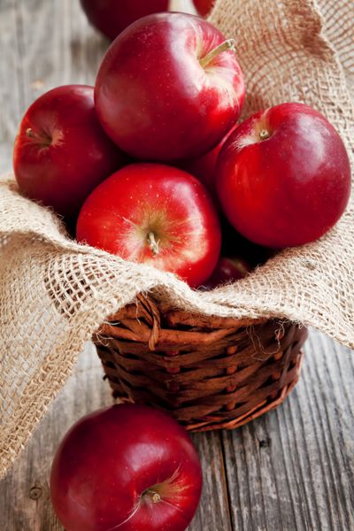 سیب های آبدار قرمز قرار داده شده در یک سبد
