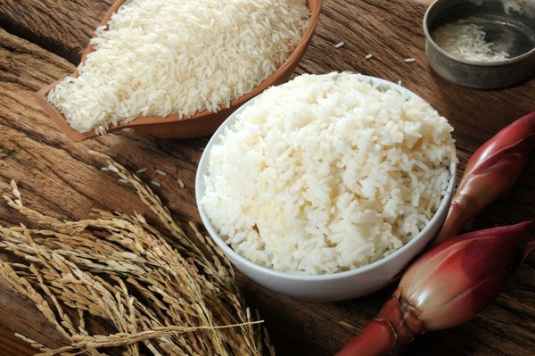 برنج پخته برنج نپخته و برنج شلتوک روی میز چوبی سه نوع برنج