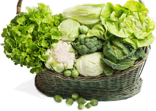 سبزیجات سبز در سبد سبز حصیری جدا شده روی سفید