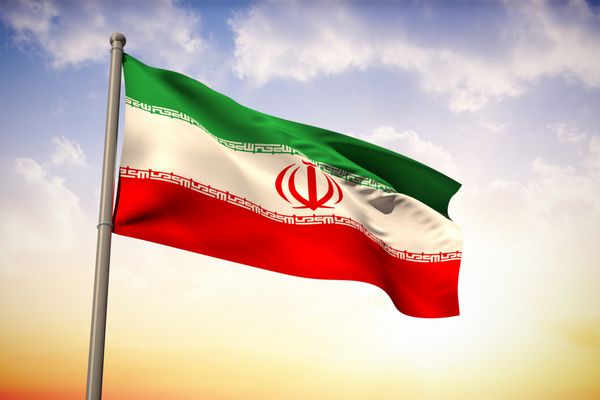 پرچم ملی ایران در مقابل آسمان زیبای نارنجی و آبی